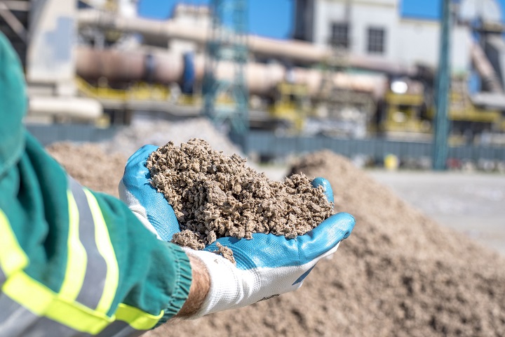 A person holding shredded paper used as an alternative fuel